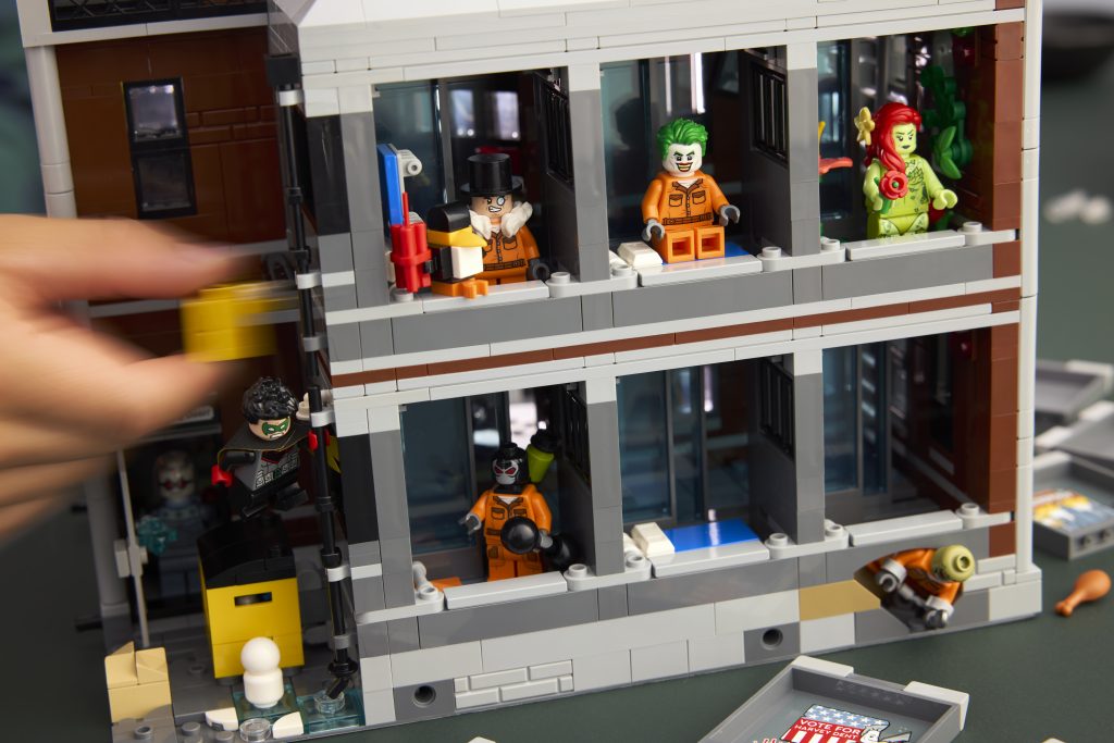 Detailed view of Arkham Asylum interior cells with Penguin, Joker, Poison Ivy, and others in their cells