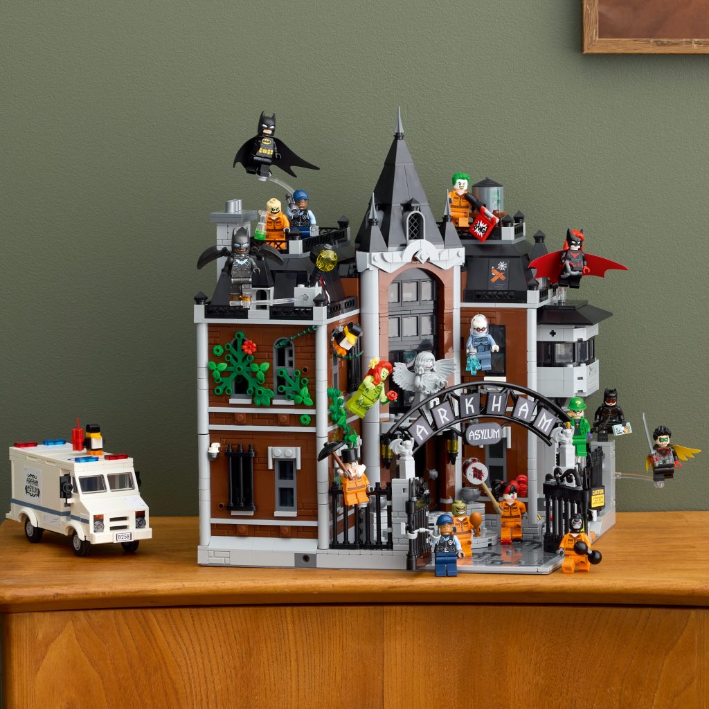 Full build of the LEGO Arkham Asylum with Batman, villains, and security van on display against a green wall