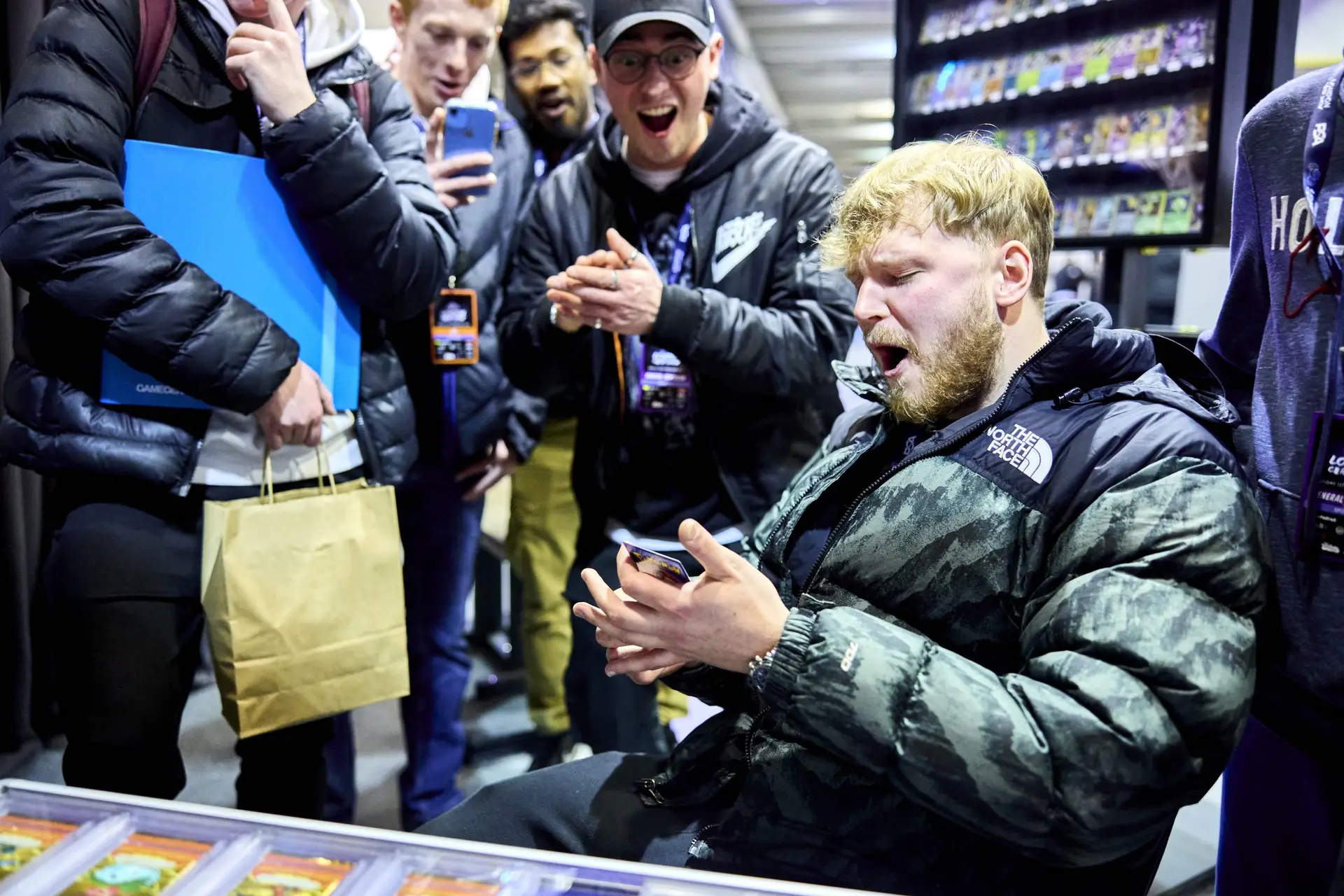 Excited group reacts as collector pulls a rare trading card at the London Card Show
