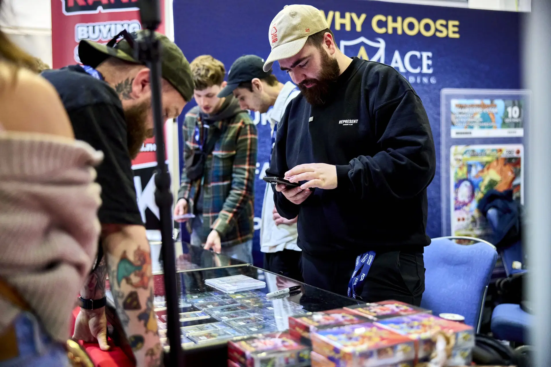 Collectors browsing graded cards and sealed products at the Ace Grading vendor table at LCS
