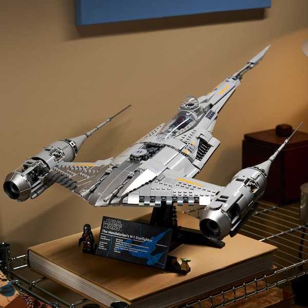 Lego Star Wars Millennium Falcon model on a stand display on a wooden surface.